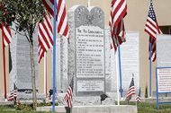 The Ten Commandments monument is photographed at the Bloomfield Municipal Complex in Bloomfield, N.M., in 2014. The concrete block that displays the Ten Commandments sits alongside other monuments related to the Declaration of Independence, the Gettysburg Address and the Bill of Rights. The city claims it took steps to avoid endorsing religion by placing disclaimers on the lawn stating that the area was a public forum for citizens to display monuments related to the city's history of law and government and that the privately-funded monuments did not necessarily reflect the opinions of the city. 