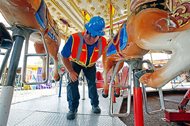 Amusement device inspector Avery Wheelock inspects the safety pins on a merry-go-round at the Mississippi State Fair in Jackson, Miss., last October. There are no federal safety standards for amusement park rides, and states’ individual regulations are vastly different from each other. 