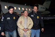 In this Jan. 19 file photo, authorities escort Joaquin “El Chapo” Guzman (center) from a plane to a waiting caravan of SUVs at Long Island MacArthur Airport, in Ronkonkoma, N.Y. Guzman is scheduled to appear in federal court in Brooklyn today, where he’s seeking to have his public defenders replaced by private lawyers, but questions remain about how they will get paid. 