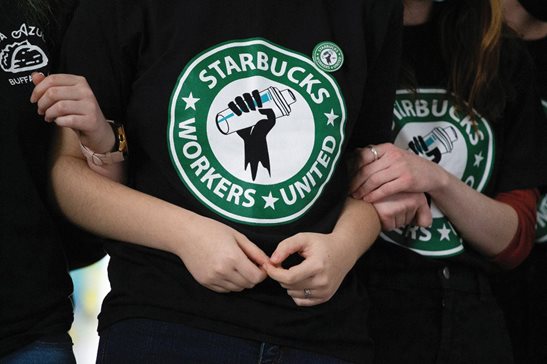 Starbucks employees and supporters link arms during a union election watch party in 2021 in Buffalo, N.Y. The U.S. Supreme Court heard oral arguments Tuesday in a case filed by Starbucks against the National Labor Relations Board, which raised the issue of courts granting temporary injunctions sought by the agency.